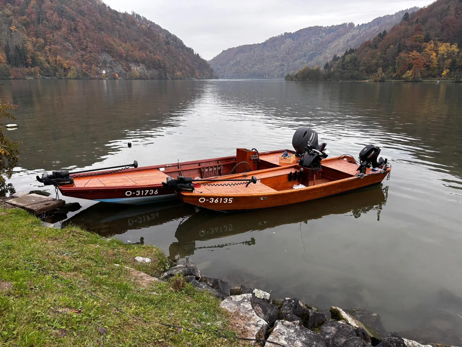 Two handcrafted wooden boats on the bank of the Danube in autumn
